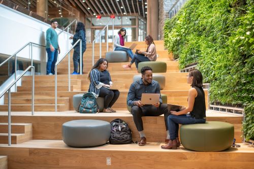 Students sitting along a staircase at the Shady Grove campus, studying and chatting.